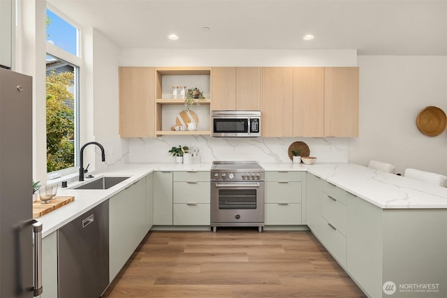 1615 N 50th St Unit A, Seattle, WA 98103 - kitchen with appliances with stainless steel finishes, a peninsula, plenty of natural light, light stone countertops, and recessed lighting