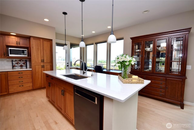 771 Brigadoon Blvd, Sequim, WA 98382 - kitchen featuring dishwasher, light countertops, light wood finished floors, brown cabinets, and hanging light fixtures