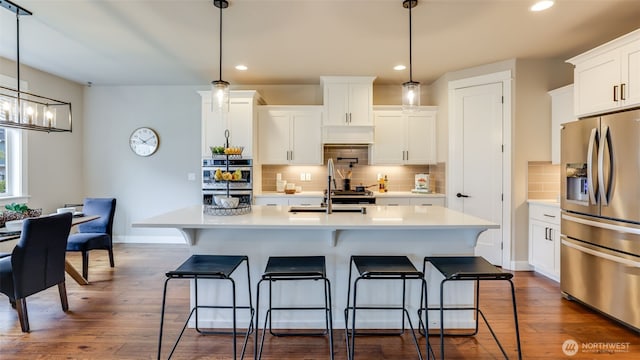 23000 SE Sycamore St, Black Diamond, WA 98010 - kitchen featuring stainless steel appliances, light countertops, recessed lighting, and a kitchen bar