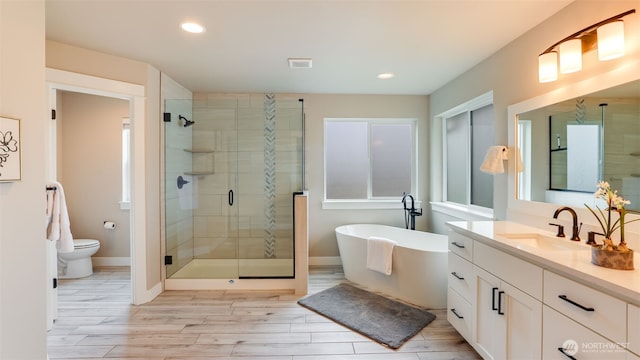 23000 SE Sycamore St, Black Diamond, WA 98010 - full bath with vanity, a shower stall, a freestanding tub, wood finished floors, and recessed lighting