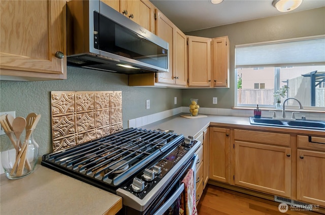 4101 Alabaster St SE, Lacey, WA 98503 - kitchen with stainless steel microwave, gas stove, light brown cabinets, light countertops, and a textured wall
