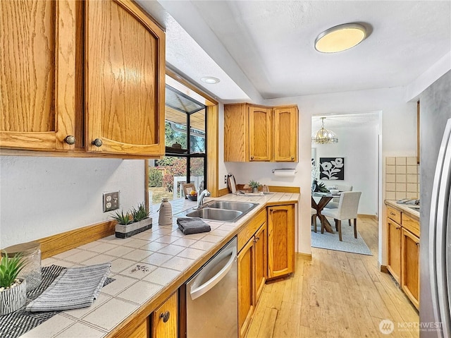 20219 7th Pl S, Des Moines, WA 98198 - kitchen with tile countertops, stainless steel dishwasher, light wood finished floors, and brown cabinetry