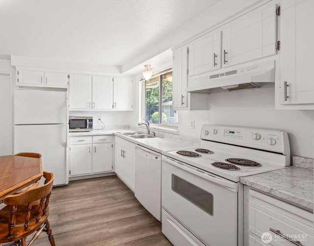 1202 Nelson St, Sedro Woolley, WA 98284 - kitchen with white appliances, under cabinet range hood, white cabinetry, and wood finished floors
