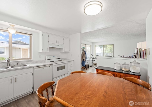 1202 Nelson St, Sedro Woolley, WA 98284 - kitchen with white appliances, under cabinet range hood, wood finished floors, a textured ceiling, and white cabinets