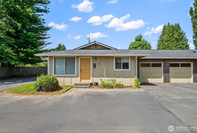 1202 Nelson St, Sedro Woolley, WA 98284 - view of front of house with board and batten siding, a garage, driveway, brick siding, and roof with shingles