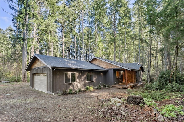 11211 Juniper Pl, Anderson Island, WA 98303 - view of front of property featuring driveway, covered porch, and a forest view