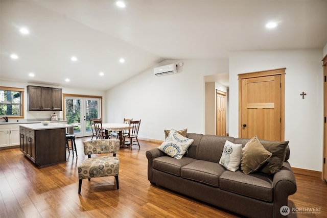 11211 Juniper Pl, Anderson Island, WA 98303 - living room with a wall mounted AC, vaulted ceiling, wood finished floors, and recessed lighting