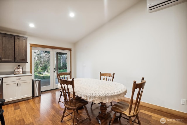 11211 Juniper Pl, Anderson Island, WA 98303 - dining room featuring french doors, vaulted ceiling, a wall mounted air conditioner, light wood-style floors, and recessed lighting