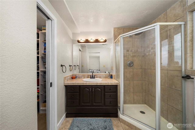 2505 211th Ave E, Lake Tapps, WA 98391 - bathroom with vanity, tile patterned flooring, a stall shower, and a walk in closet
