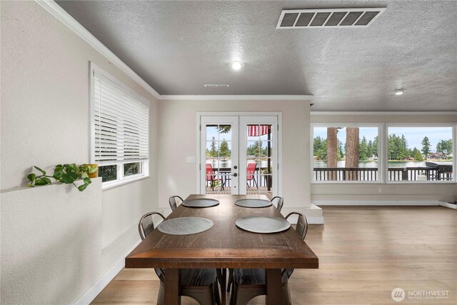 2505 211th Ave E, Lake Tapps, WA 98391 - dining room with wood finished floors, french doors, a water view, ornamental molding, and a textured ceiling