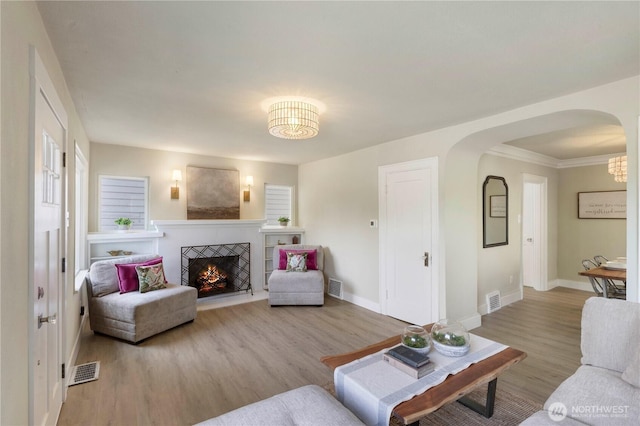 1206 S 14th St, Tacoma, WA 98405 - living area featuring arched walkways, wood finished floors, a fireplace, and crown molding