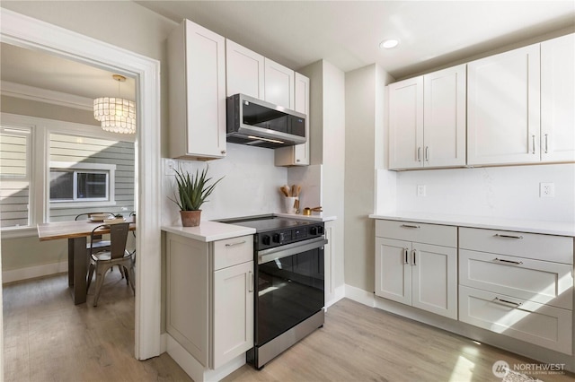1206 S 14th St, Tacoma, WA 98405 - kitchen with electric stove, stainless steel microwave, light wood-style flooring, light countertops, and recessed lighting