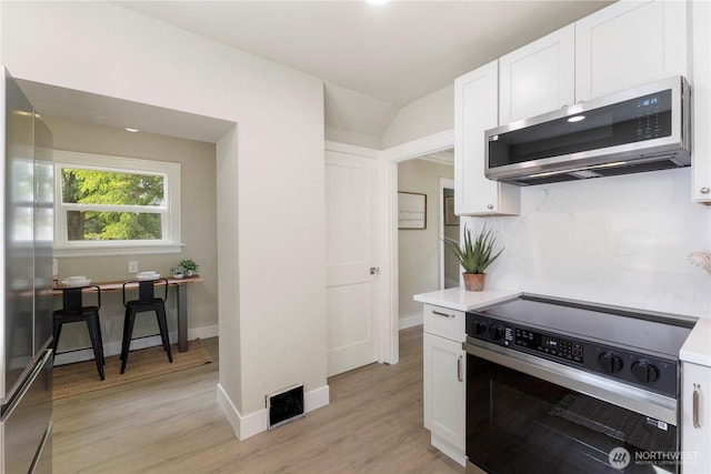 1206 S 14th St, Tacoma, WA 98405 - kitchen featuring appliances with stainless steel finishes, white cabinets, light wood finished floors, and backsplash