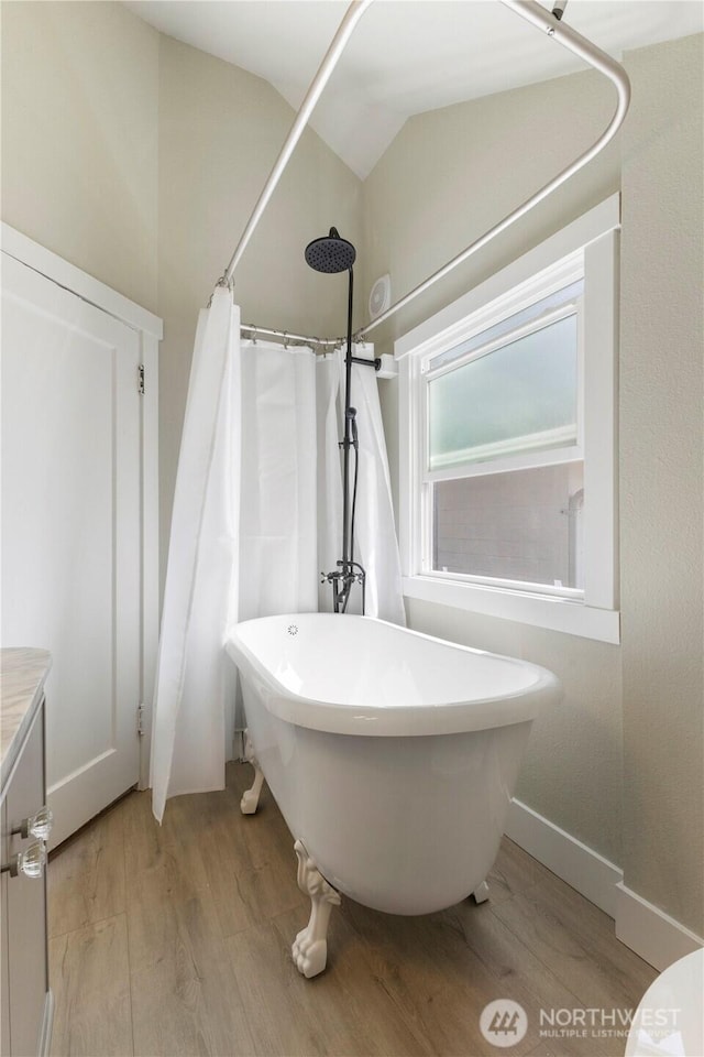 1206 S 14th St, Tacoma, WA 98405 - full bath featuring wood finished floors, a freestanding tub, vaulted ceiling, curtained shower, and vanity