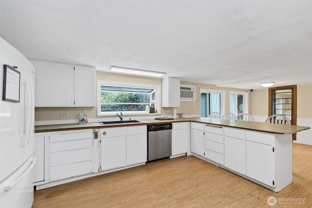 429 170th St S, Spanaway, WA 98387 - kitchen featuring dishwasher, freestanding refrigerator, light wood finished floors, a peninsula, and an AC wall unit