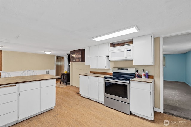 429 170th St S, Spanaway, WA 98387 - kitchen featuring stainless steel range with electric stovetop, white microwave, white cabinets, and light wood-type flooring
