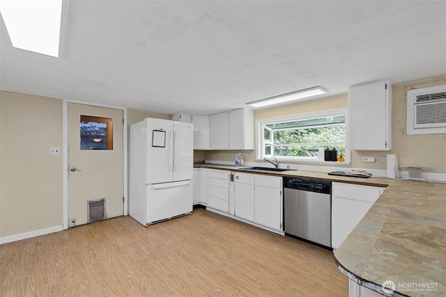 429 170th St S, Spanaway, WA 98387 - kitchen featuring freestanding refrigerator, stainless steel dishwasher, light wood-style flooring, white cabinets, and an AC wall unit