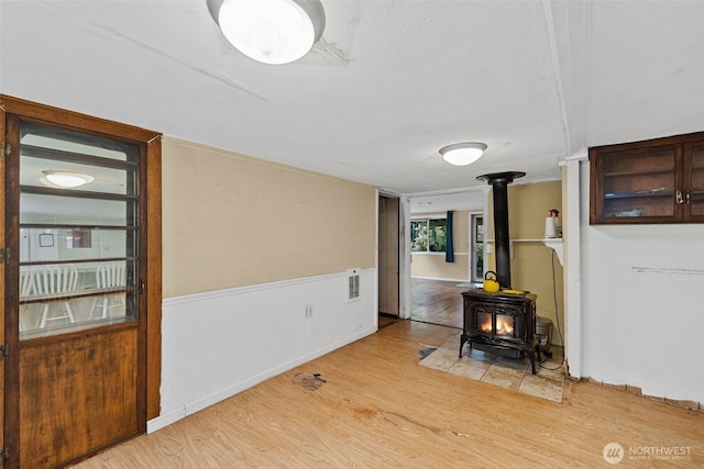 429 170th St S, Spanaway, WA 98387 - dining space featuring a wood stove, light wood-type flooring, and wainscoting