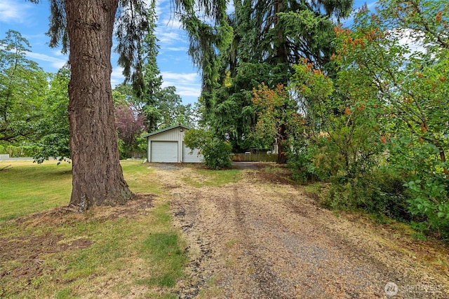 429 170th St S, Spanaway, WA 98387 - view of front of house with a detached garage, an outdoor structure, and a front yard