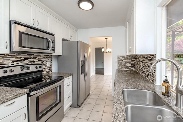 13457 SE Fairwood Blvd, Renton, WA 98058 - kitchen featuring stainless steel appliances, light tile patterned floors, white cabinetry, backsplash, and a chandelier