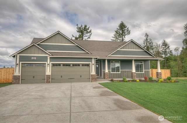 14317 Mima Rd SW, Olympia, WA 98512 - craftsman-style house featuring covered porch, a garage, driveway, roof with shingles, and stone siding