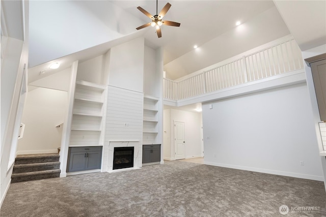 14317 Mima Rd SW, Olympia, WA 98512 - unfurnished living room with carpet flooring, a ceiling fan, high vaulted ceiling, a high end fireplace, and stairway