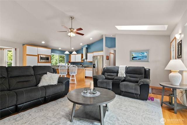 8615 176th St NW, Stanwood, WA 98282 - living area featuring light wood-type flooring, vaulted ceiling, a ceiling fan, a skylight, and recessed lighting