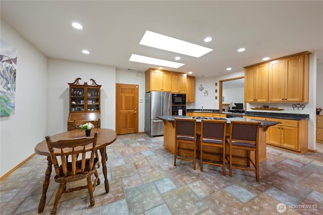 16314 2nd Dr SE, Bothell, WA 98012 - kitchen featuring black appliances, a breakfast bar, recessed lighting, light stone finish floors, and a center island