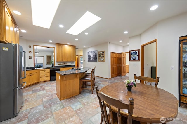 16314 2nd Dr SE, Bothell, WA 98012 - kitchen featuring freestanding refrigerator, dishwasher, a breakfast bar, light stone finish flooring, and recessed lighting