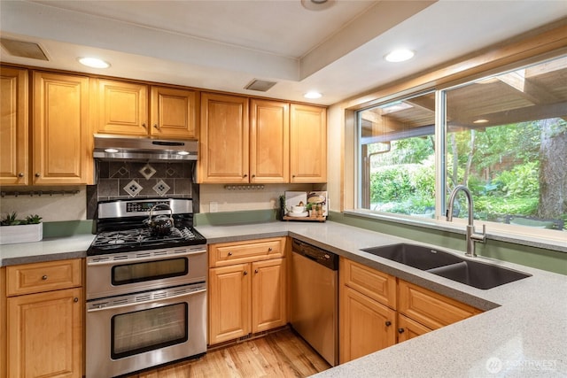 822 206th Ave NE, Sammamish, WA 98074 - kitchen featuring stainless steel appliances, under cabinet range hood, recessed lighting, light wood-style floors, and decorative backsplash