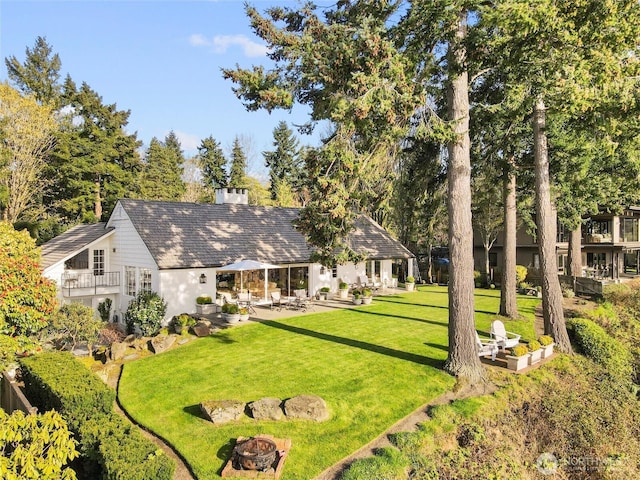 19263 Edgecliff Dr SW, Normandy Park, WA 98166 - back of property with a yard, an outdoor fire pit, a chimney, and a patio area