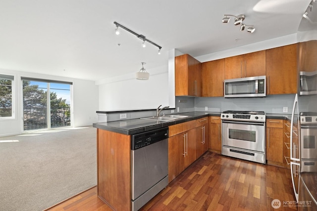 124 Bellevue Ave E Unit 504, Seattle, WA 98102 - kitchen featuring stainless steel appliances, brown cabinets, dark countertops, open floor plan, and a peninsula