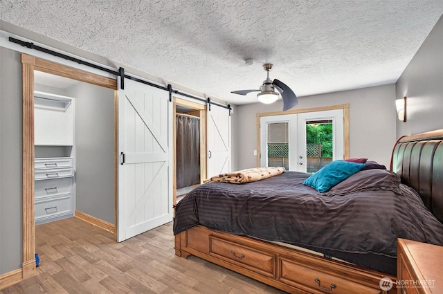 132 Tanglewood Dr, Longview, WA 98632 - bedroom with a barn door, access to exterior, french doors, light wood-style floors, and ceiling fan