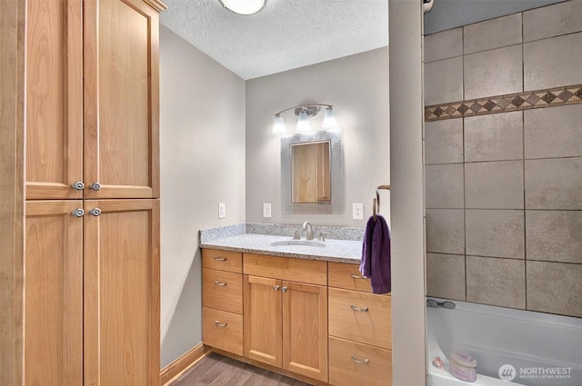 132 Tanglewood Dr, Longview, WA 98632 - full bathroom with vanity, wood finished floors, a textured ceiling, and shower / tub combination
