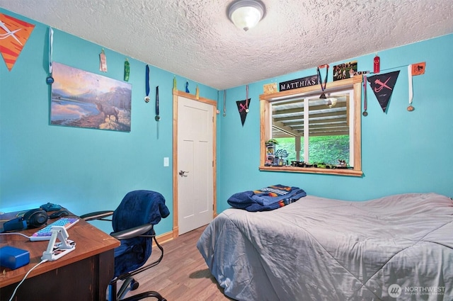 132 Tanglewood Dr, Longview, WA 98632 - bedroom with wood finished floors, a textured ceiling, and a desk