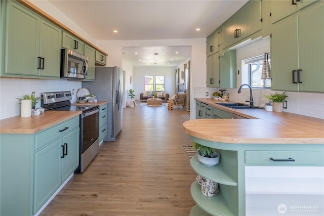 5502 Chuckanut Dr, Bow, WA 98232 - kitchen with appliances with stainless steel finishes, green cabinets, open shelves, light countertops, and light wood finished floors