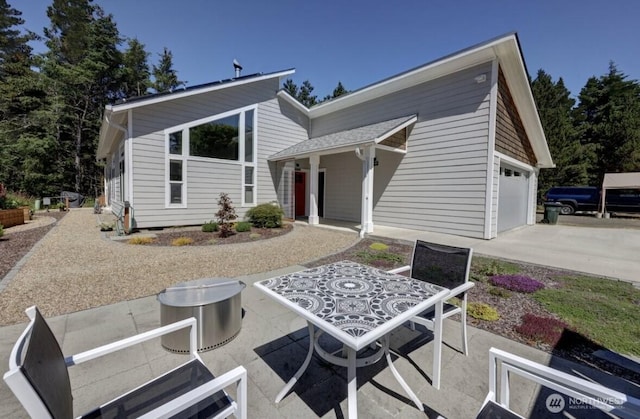 999 41st Ln, Seaview, WA 98644 - rear view of property with concrete driveway, a garage, and a patio