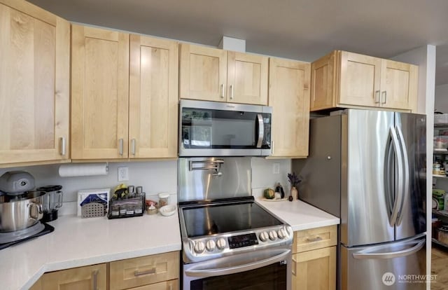 999 41st Ln, Seaview, WA 98644 - kitchen featuring appliances with stainless steel finishes, light brown cabinetry, and light countertops