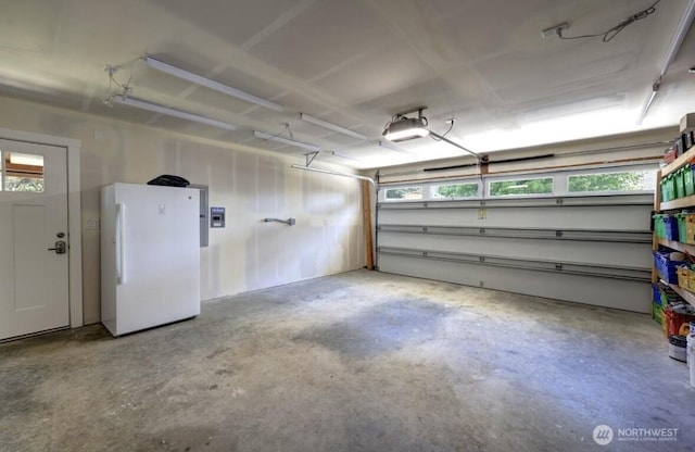 999 41st Ln, Seaview, WA 98644 - garage featuring freestanding refrigerator and a garage door opener