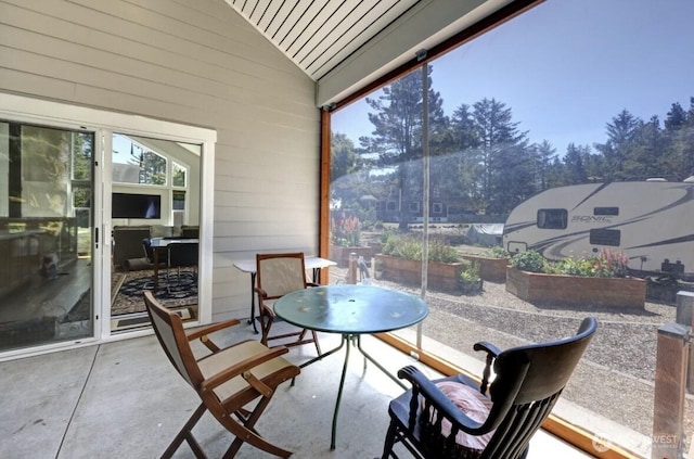 999 41st Ln, Seaview, WA 98644 - sunroom / solarium featuring lofted ceiling, healthy amount of natural light, outdoor dining area, concrete floors, and wood walls