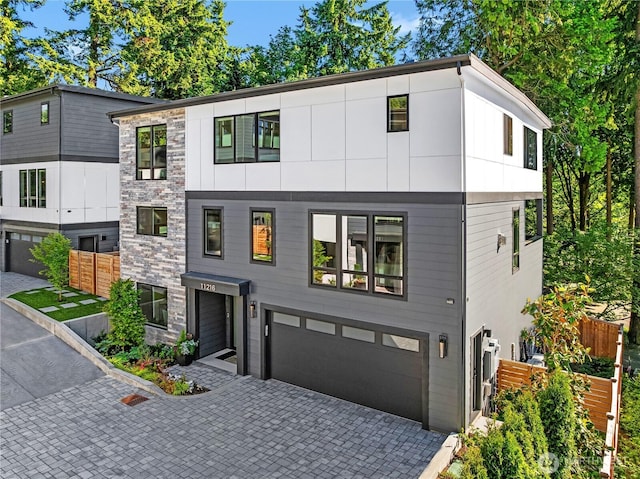 11216 NE 67th St Unit 4, Kirkland, WA 98033 - contemporary home with an attached garage, decorative driveway, and stone siding