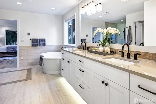 11216 NE 67th St Unit 4, Kirkland, WA 98033 - bathroom with double vanity, a shower stall, a freestanding bath, tile walls, and recessed lighting