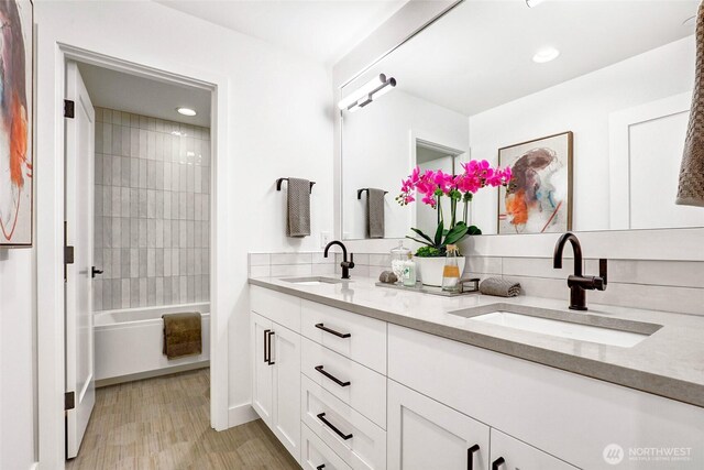 11216 NE 67th St Unit 4, Kirkland, WA 98033 - full bathroom with double vanity, wood finished floors, washtub / shower combination, and recessed lighting
