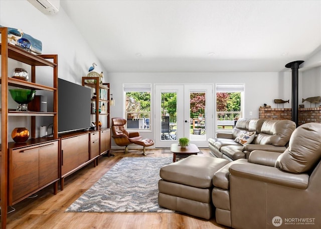 1043 NE Pennington Loop, Coupeville, WA 98239 - living area featuring a wood stove, light wood finished floors, vaulted ceiling, and a wall unit AC