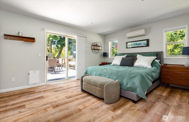 1043 NE Pennington Loop, Coupeville, WA 98239 - bedroom with a wall unit AC, access to outside, and wood finished floors