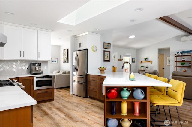 1043 NE Pennington Loop, Coupeville, WA 98239 - kitchen featuring stainless steel fridge with ice dispenser, open floor plan, a peninsula, a skylight, and open shelves