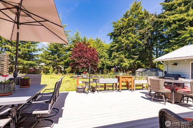 1043 NE Pennington Loop, Coupeville, WA 98239 - wooden deck featuring outdoor dining space, a storage shed, and a fenced backyard