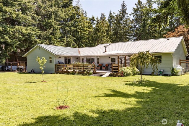 1043 NE Pennington Loop, Coupeville, WA 98239 - back of property with a wooden deck, a yard, and a metal roof