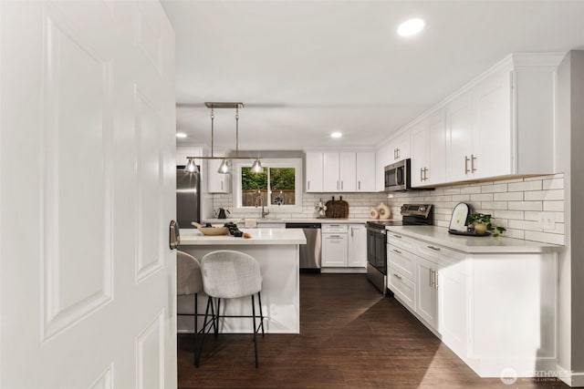 10403 Wauna St SW, Lakewood, WA 98498 - kitchen featuring appliances with stainless steel finishes, a breakfast bar area, decorative backsplash, white cabinetry, and light countertops