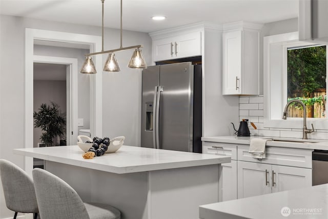 10403 Wauna St SW, Lakewood, WA 98498 - kitchen featuring appliances with stainless steel finishes, white cabinetry, a breakfast bar area, tasteful backsplash, and recessed lighting